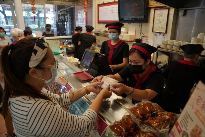 高市府員工揪團買午餐，消費金額滿五百元兌換到一百元高雄券，當場加點兩樣菜。  圖片來源：高市府經發局