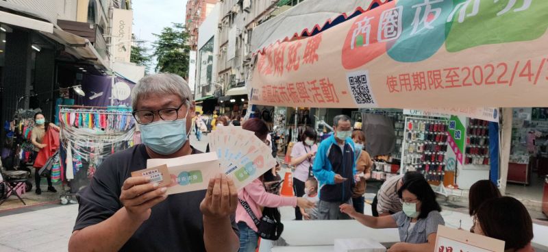 民眾於高雄市新堀江商圈拿著8張面額各50元的商圈夜市券及其兌換碼。 圖片來源:高市府經發局 民眾於高雄市新堀江商圈拿著8張面額各50元的商圈夜市券及其兌換碼。 圖片來源:高市府經發局