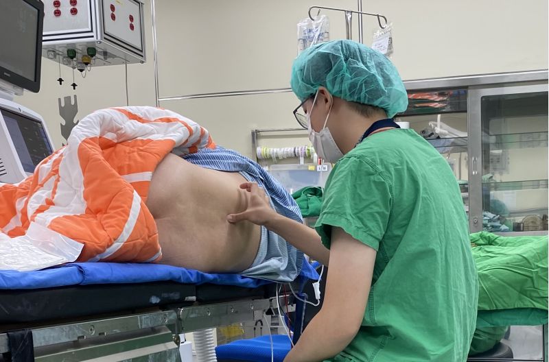 注射麻醉藥物前，麻醉科醫師正在確認病人腰椎位置。  圖片來源：新竹臺大分院