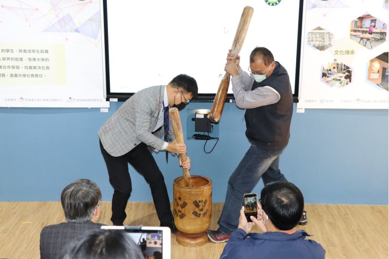 玄奘大學簡紹琦校長與新竹和平(麥巴萊)部落竹林養生村合作社執行長郭文標於開幕儀式搗麻糬，祝福成果展順利。  圖片來源：玄大