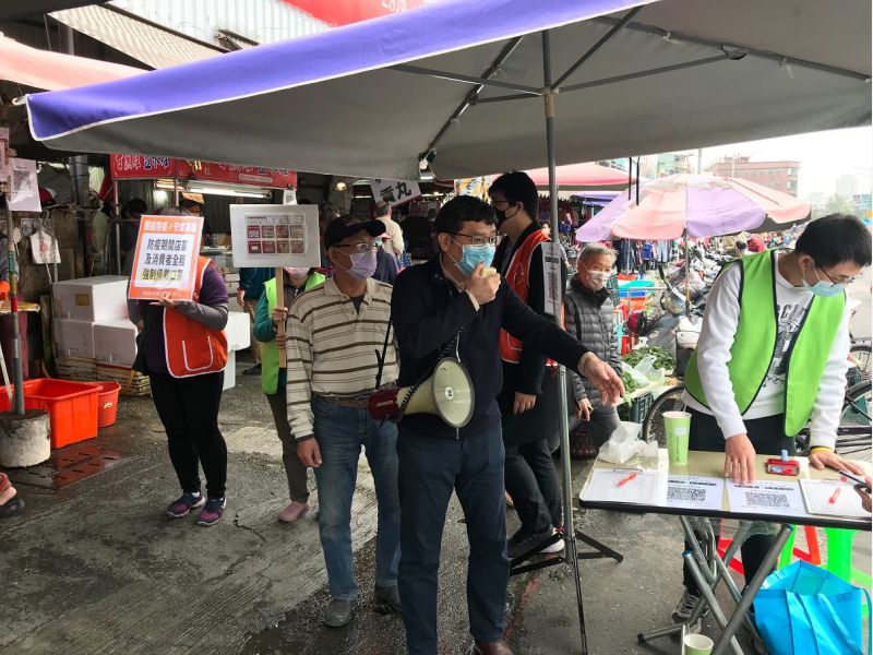 高市府經發局副局長高鎮遠(中)12日手持大聲公於哈囉市場出入口宣導消費者需全程佩戴口罩、禁試吃及落實實聯制等防疫措施。 圖片來源:高市府經發局 高市府經發局副局長高鎮遠(中)12日手持大聲公於哈囉市場出入口宣導消費者需全程佩戴口罩、禁試吃及落實實聯制等防疫措施。 圖片來源:高市府經發局