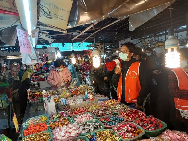 高市府經發局防疫人員手持大聲公在市場逐攤宣導消費者需全程佩戴口罩、禁止試吃及落實實聯制等防疫措施。 圖片來源:高市府經發局 高市府經發局防疫人員手持大聲公在市場逐攤宣導消費者需全程佩戴口罩、禁止試吃及落實實聯制等防疫措施。 圖片來源:高市府經發局