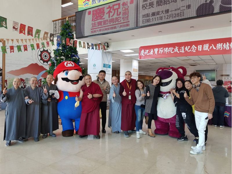 玄奘大學為慶祝法寶節佛陀成道紀念日於12月28日舉辦「臘八粥結緣」活動,學生裝扮成草莓熊抱哥與日本電動角色瑪莉歐宣傳施粥活動,和現場的師生親切互動。 圖片來源:玄奘大學 玄奘大學為慶祝法寶節佛陀成道紀念日於12月28日舉辦「臘八粥結緣」活動,學生裝扮成草莓熊抱哥與日本電動角色瑪莉歐宣傳施粥活動,和現場的師生親切互動。 圖片來源:玄奘大學