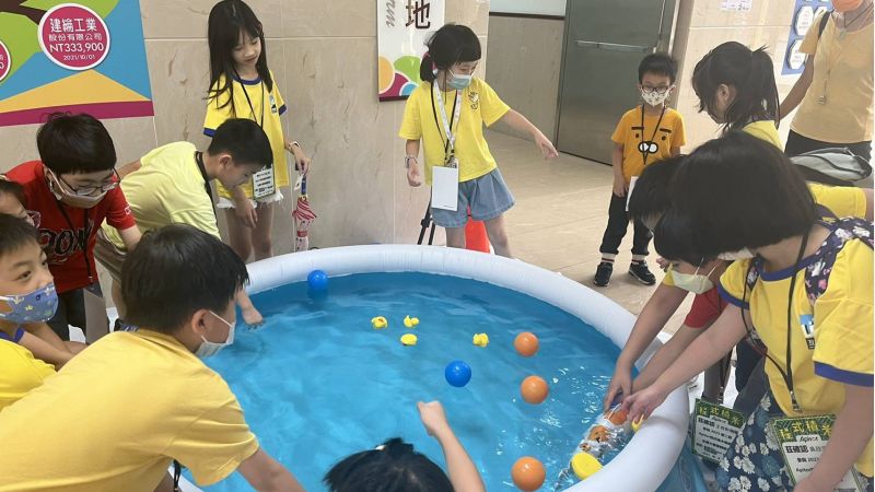 小朋友好奇地伸手逗弄現場展示的仿生機器魚 圖片來源:明新科大 小朋友好奇地伸手逗弄現場展示的仿生機器魚 圖片來源:明新科大