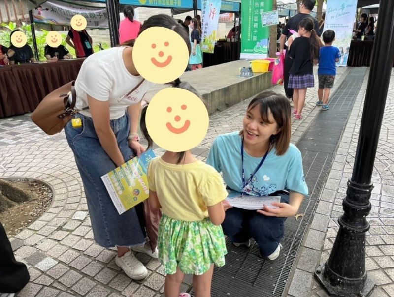 玄奘大學社會工作學系夏婉珍同學於市府擺攤宣導時，與小小孩講解題目。  圖片來源：玄奘大學
