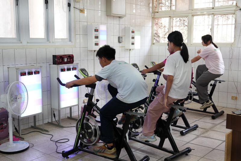同學踩腳踏車所產出的電流，即可讓前方設置的電風扇運轉_